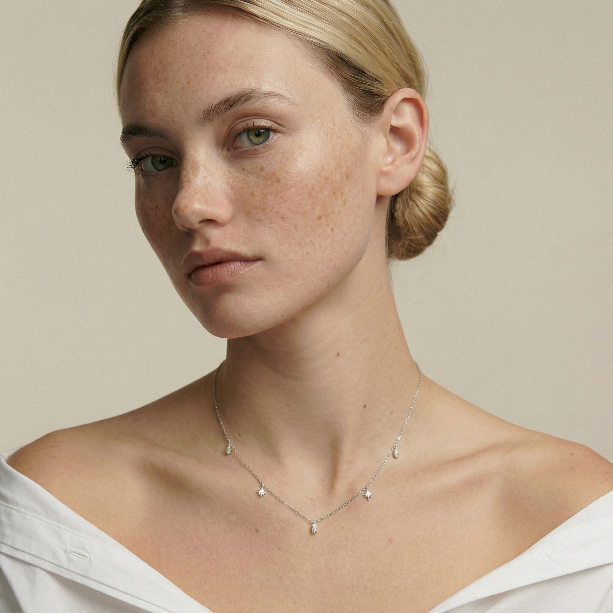 Model wearing a delicate sterling silver zircon necklace with star and water-droplet charms, lightweight women’s jewellery