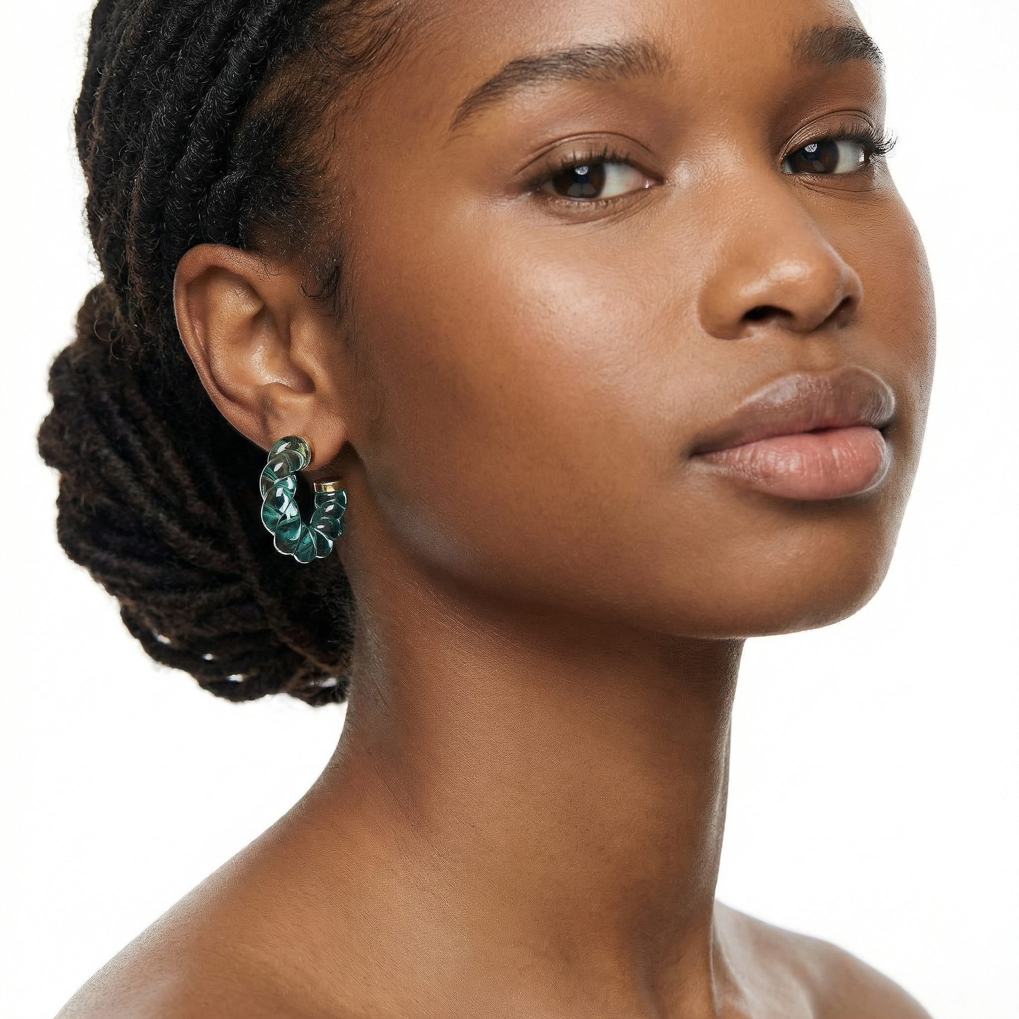 Transparent twisted geometry hoop earrings in seafoam green aqua with gold-toned electroplated stainless steel studs worn on model